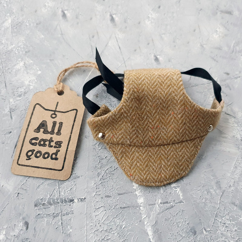 Tweed-style hat for a cat with a small brim  shown on a grey textured