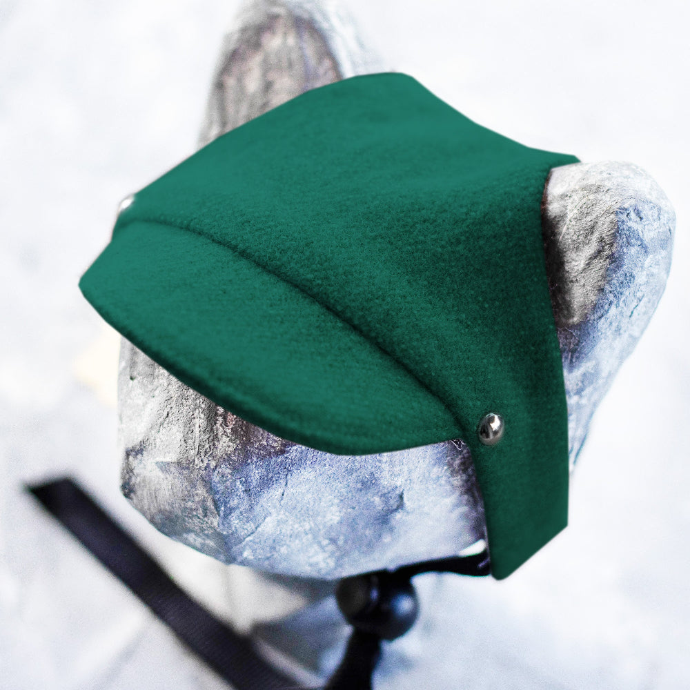 Green flat cap on a mannequin head against a white background