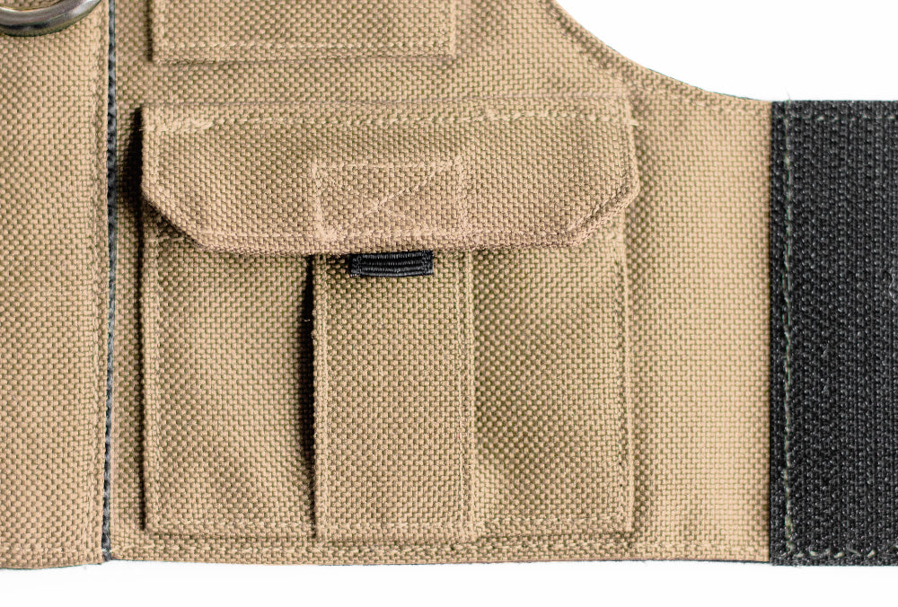 Tan pet harness designed with a utility vest appearance, featuring several small pockets, a leash attachment ring, and a customizable name patch.