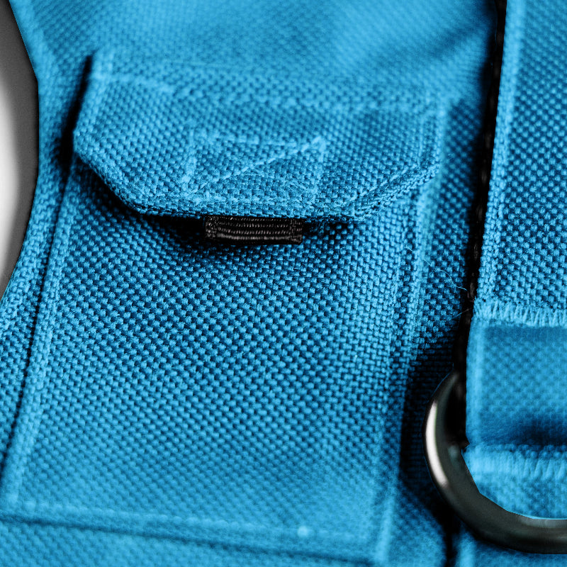 Cat harness designed with a utility vest appearance, featuring several small pockets, a leash attachment ring, and a customizable name patch.