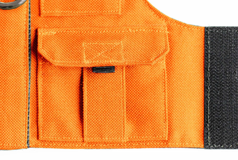 Cat harness designed with a utility vest appearance, featuring several small pockets, a leash attachment ring, and a customizable name patch.