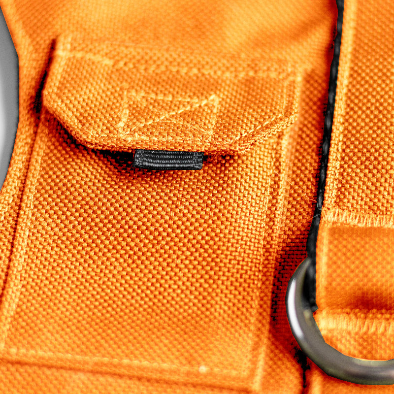 Cat harness designed with a utility vest appearance, featuring several small pockets, a leash attachment ring, and a customizable name patch.