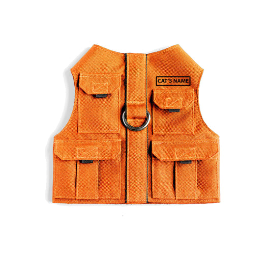 Cat harness designed with a utility vest appearance, featuring several small pockets, a leash attachment ring, and a customizable name patch.