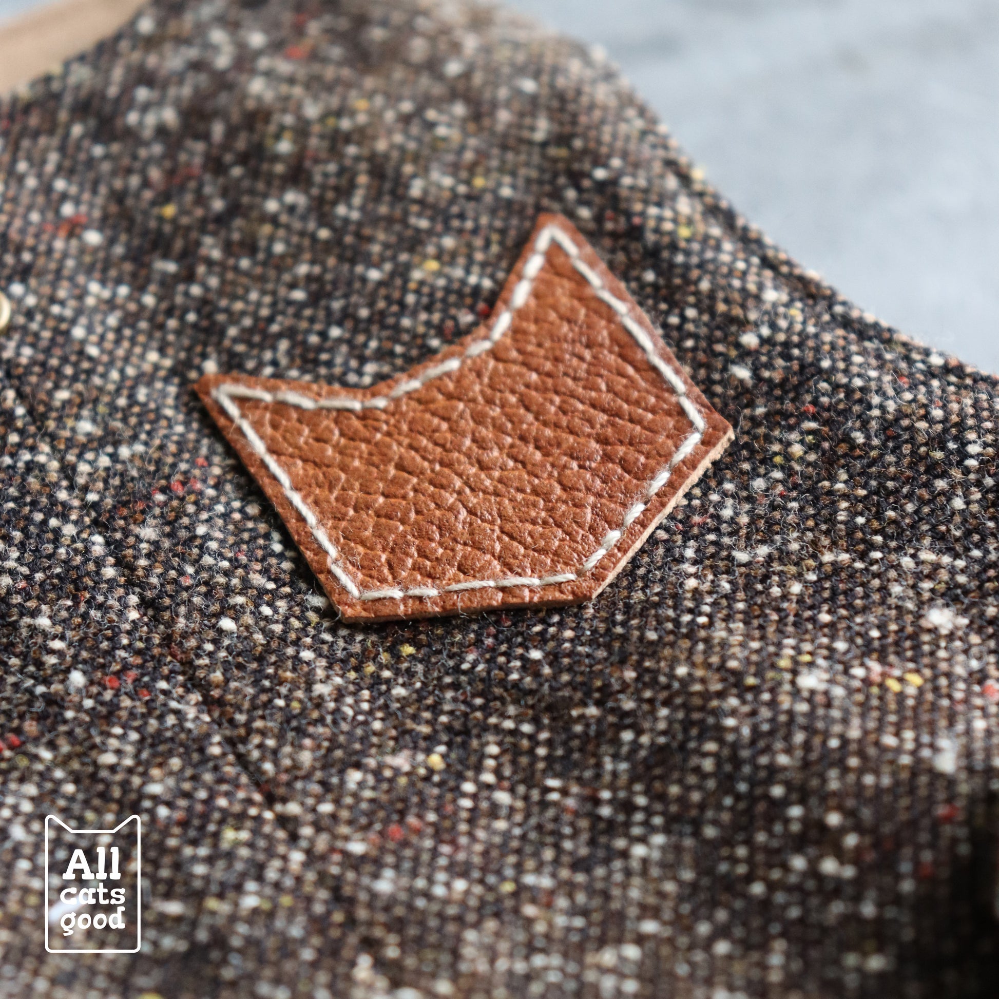 Close-up: Distinctive Cat Head Patch on a Stylish Tweed Harness by All Cats Good. Shop Unique Pet Accessories!