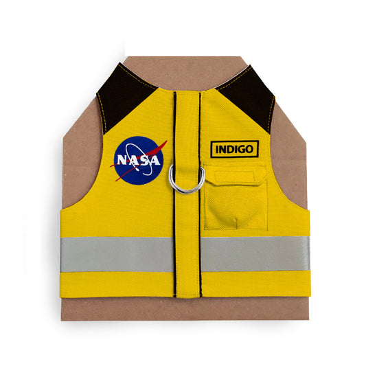 Yellow cat harness with black shoulder accents, a NASA logo patch, a reflective silver stripe, and AirTag pocket