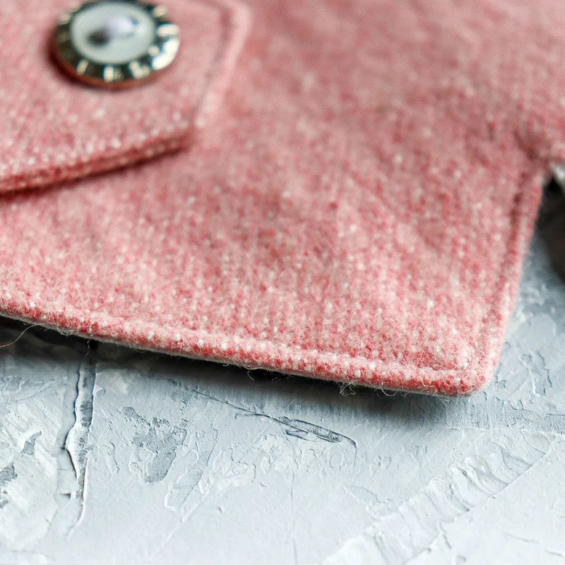Close-up of a light pink tweed cat harness.