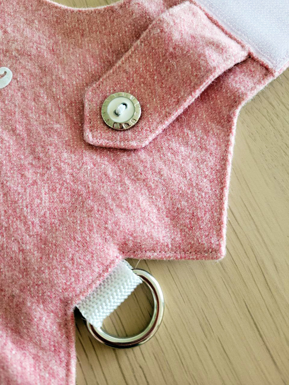 A pink tweed cat harness with a silver mountain patch, decorative buttons, and a black D-ring