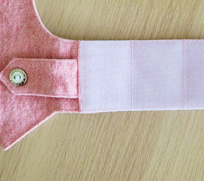 A pink tweed cat harness with a silver mountain patch, decorative buttons, and a black D-ring