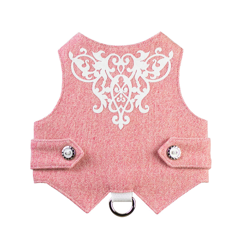A pink tweed cat harness with white decorative embroidery on the back, silver and black buttons, and a silver D-ring.
