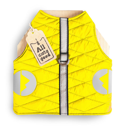 A quilted yellow cat harness with reflective silver stripes, circular reflective elements, and a brown "Allcatsgood" tag.