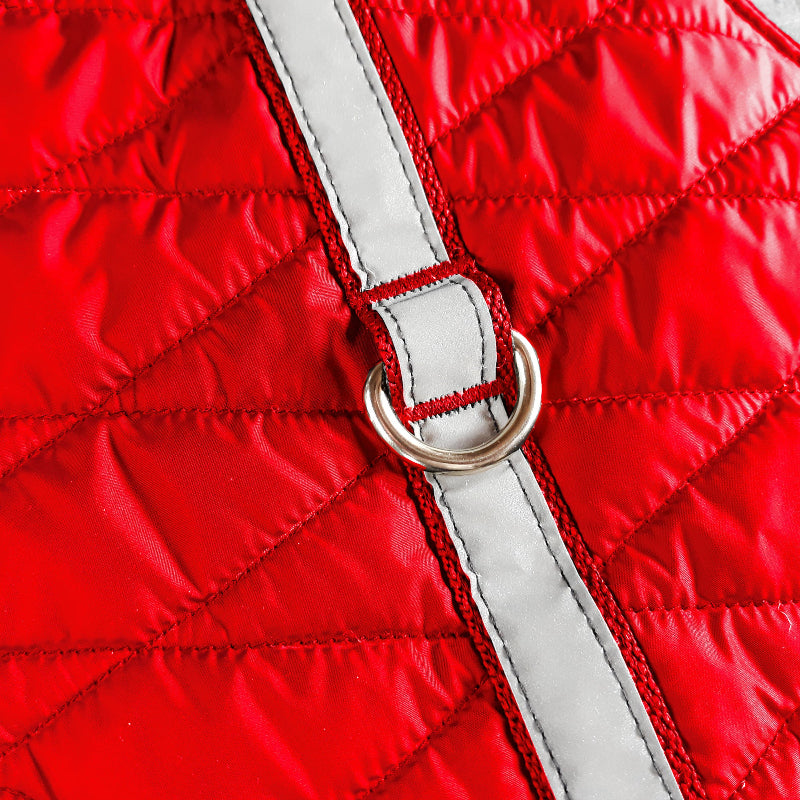 A quilted red cat harness with reflective silver stripes, circular reflective elements