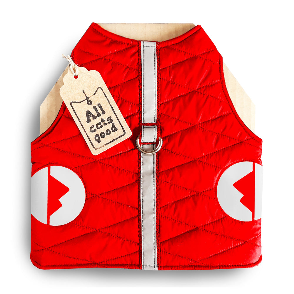 A quilted red cat harness with reflective silver stripes, circular reflective elements, and a brown "Allcatsgood" tag.
