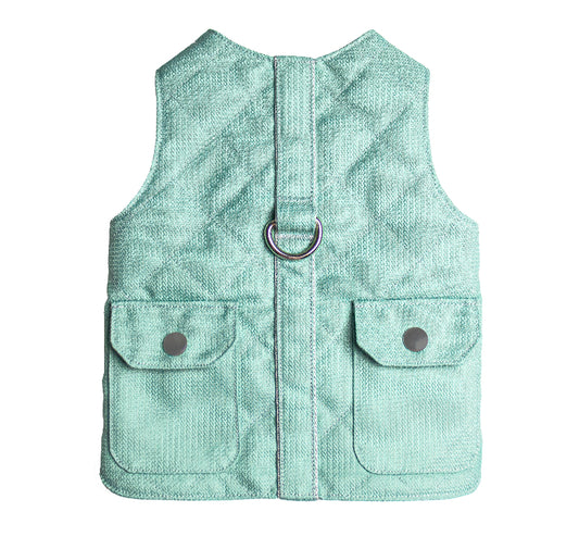 Light blue quilted cat harness with a vest-like design, featuring two small pockets with snap closures and a silver D-ring.