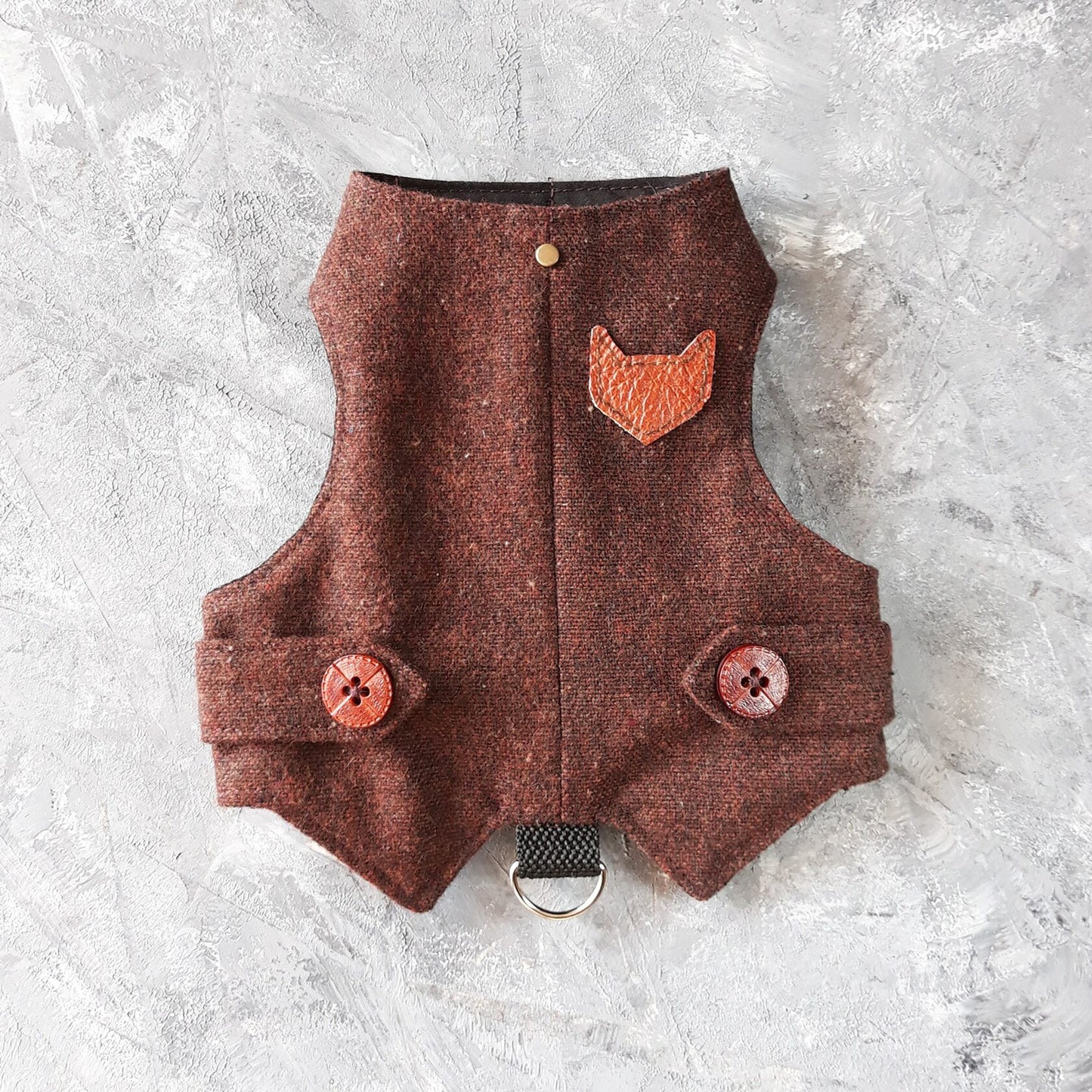 A burgundy tweed cat harness with a brown faux leather cat-shaped patch, decorative buttons, and a black D-ring.
