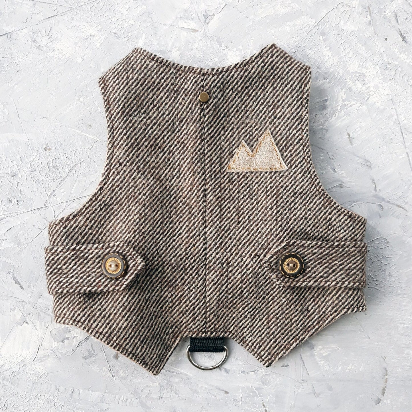 A brown tweed cat harness with a diagonal stripes pattern and decorative details.
