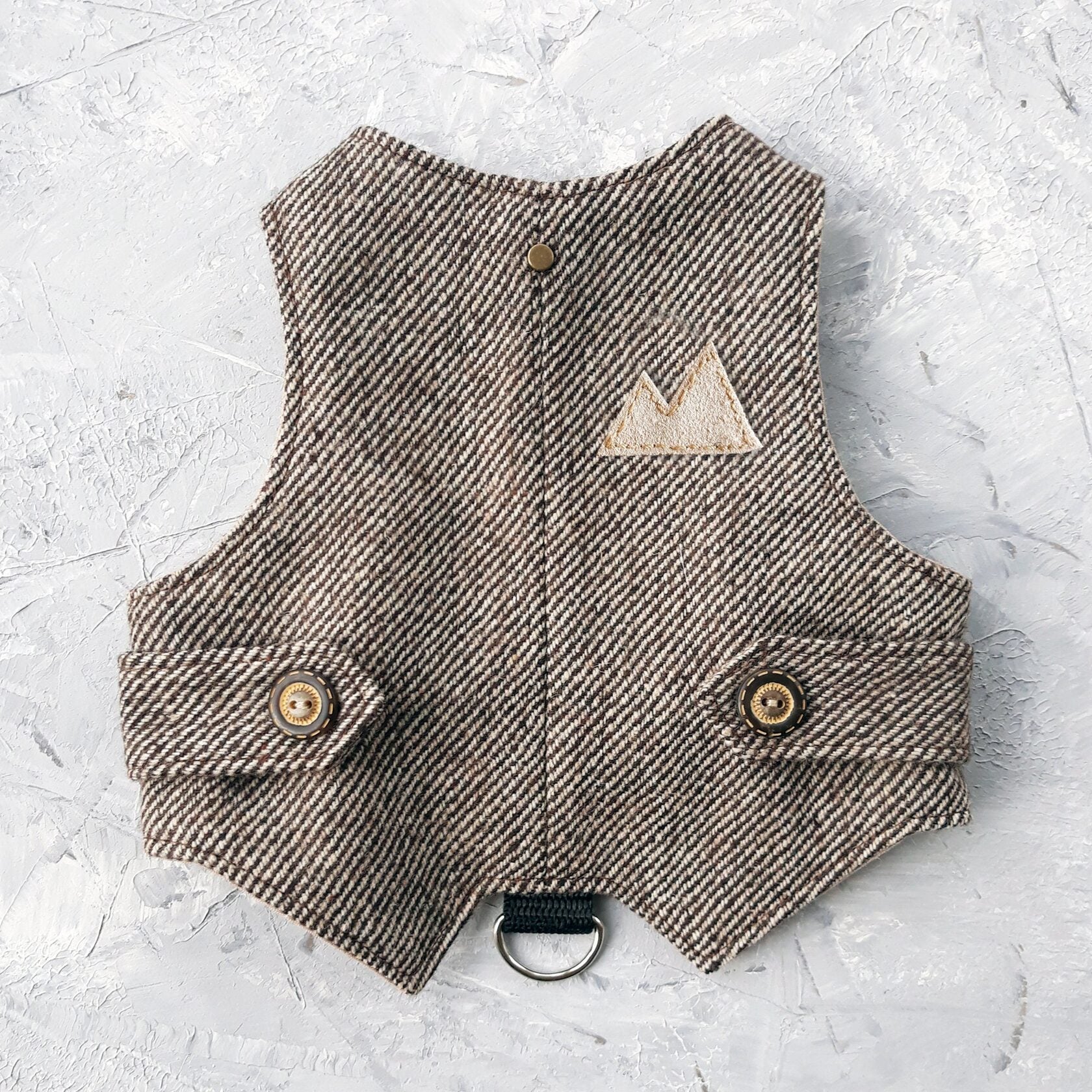 A brown tweed cat harness with a diagonal stripes pattern and decorative details.