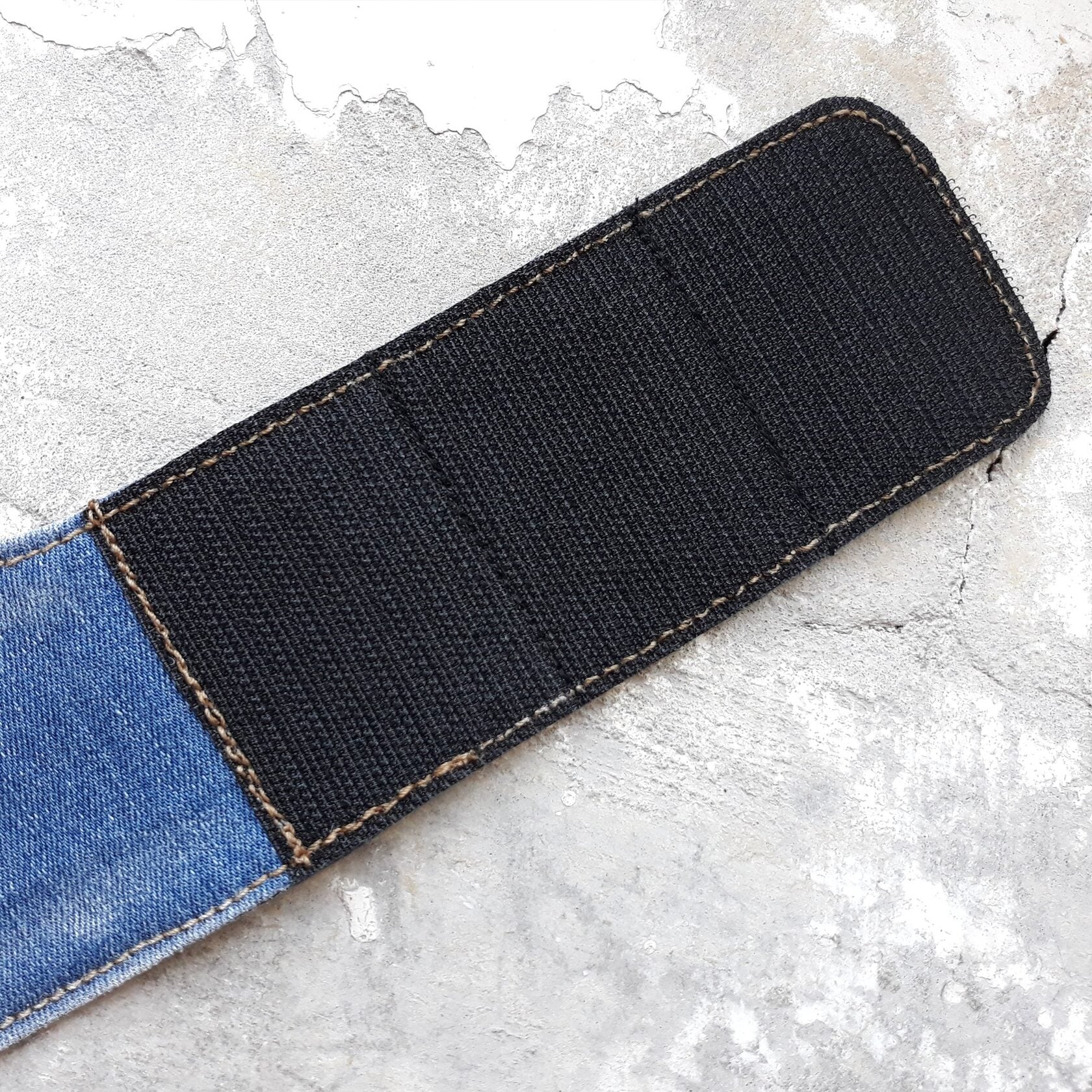 Close-up of the black Velcro on a denim cat harness strap.