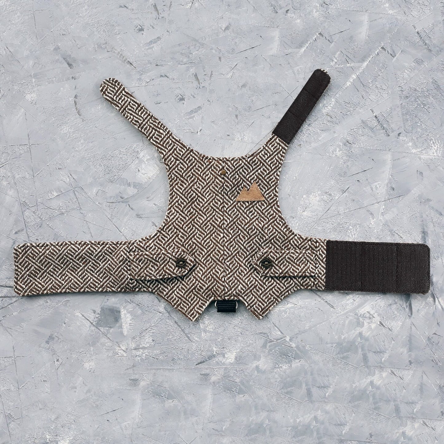 A brown tweed cat harness with a geometric pattern laid flat.