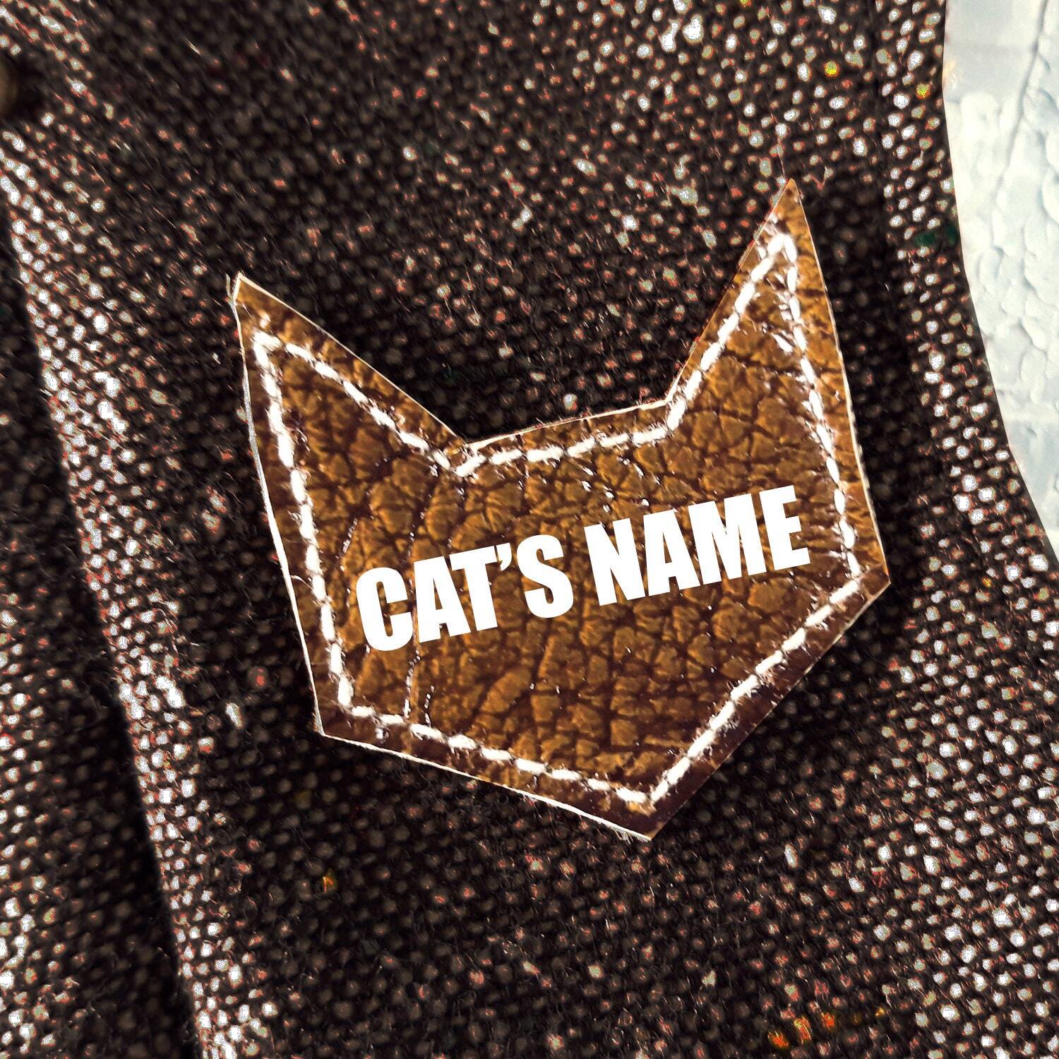 Close-up: Personalised "Cat's Name" Patch on a Stylish Tweed Harness. Make It Uniquely Yours! Shop Custom Cat Wear Today.