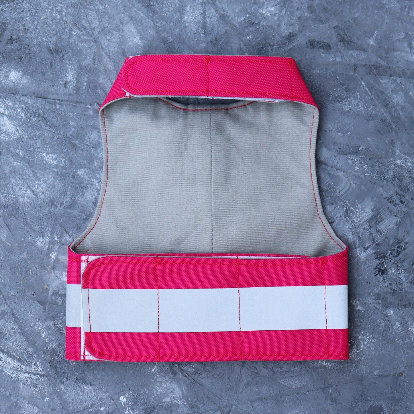 Overhead view of the inner lining of a bright pink high-visibility cat harness