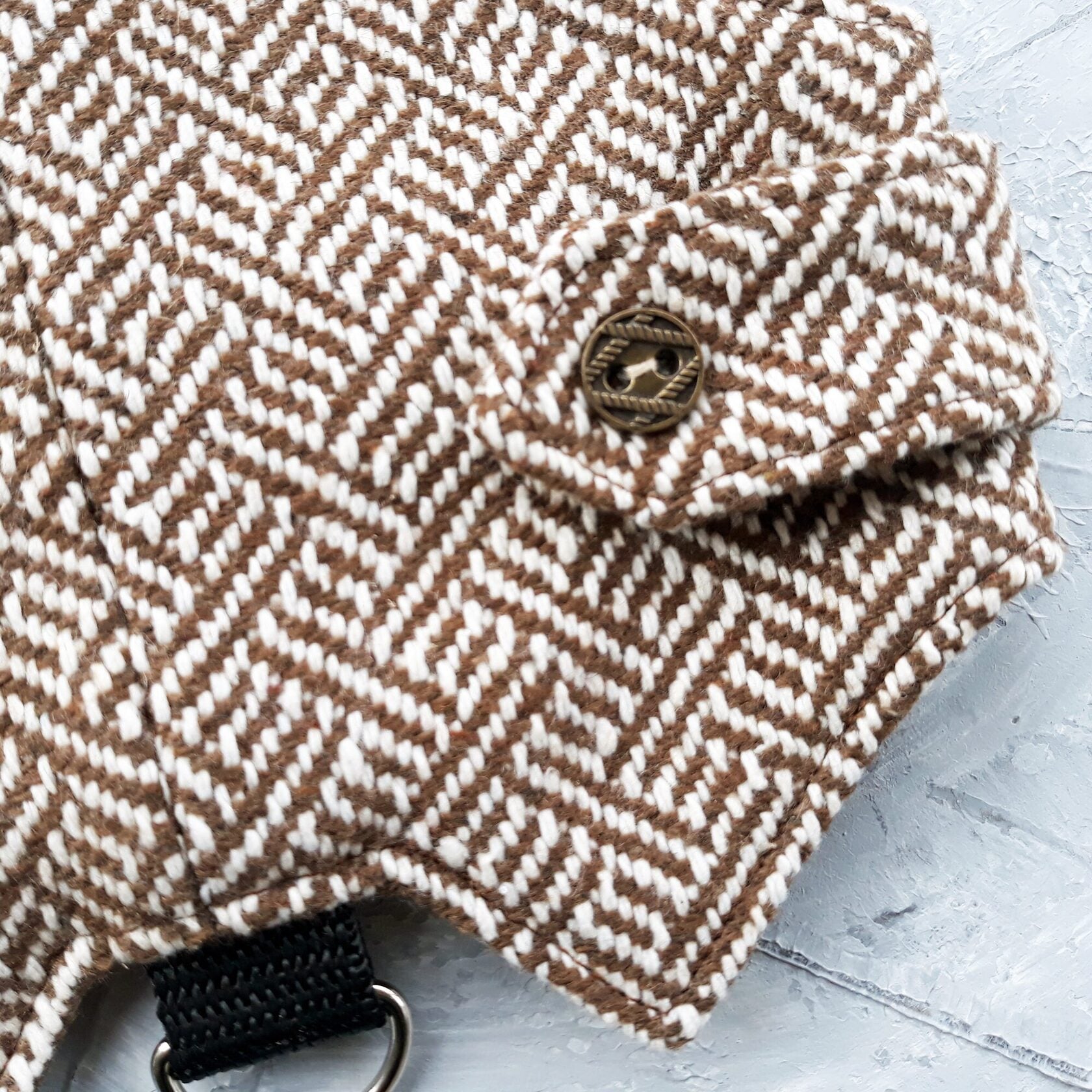 Close-up of the tweed fabric, button on a cat harness.