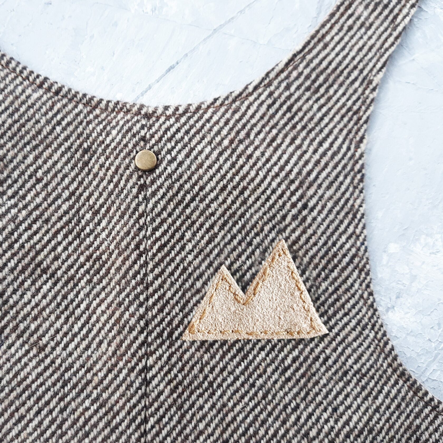 A brown tweed cat harness with a diagonal stripes pattern and decorative details.