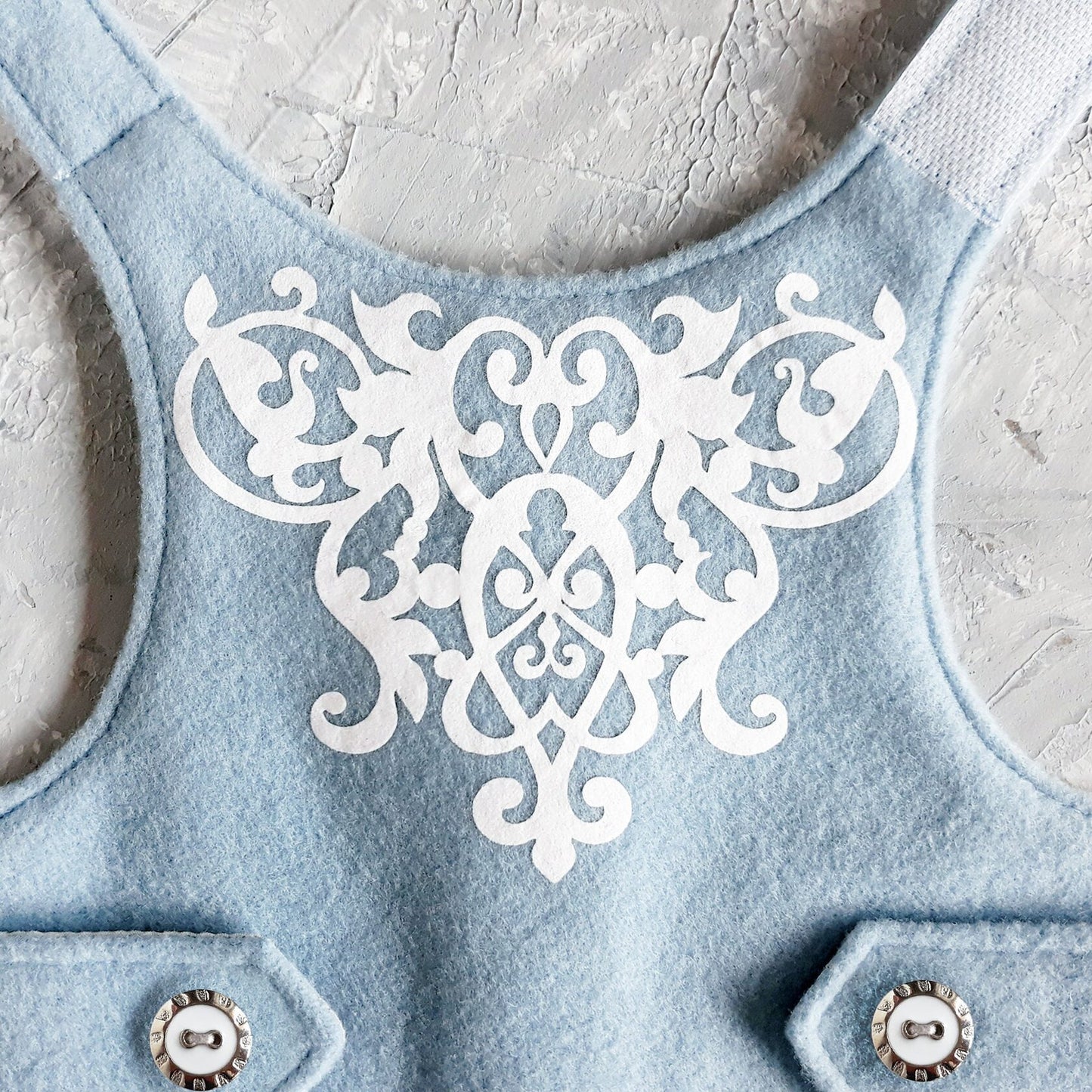 White decorative design on a blue cat harness.