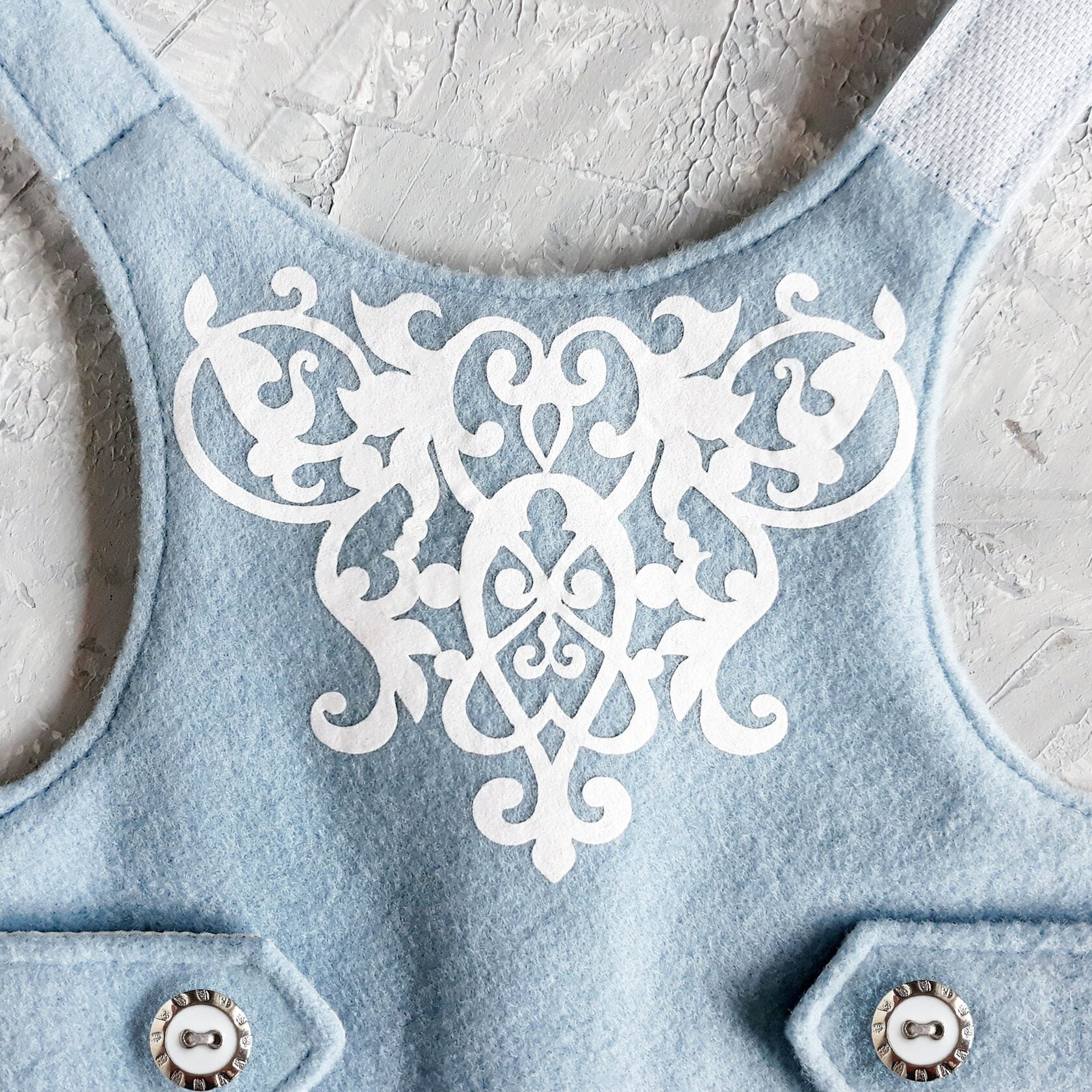 White decorative design on a blue cat harness.