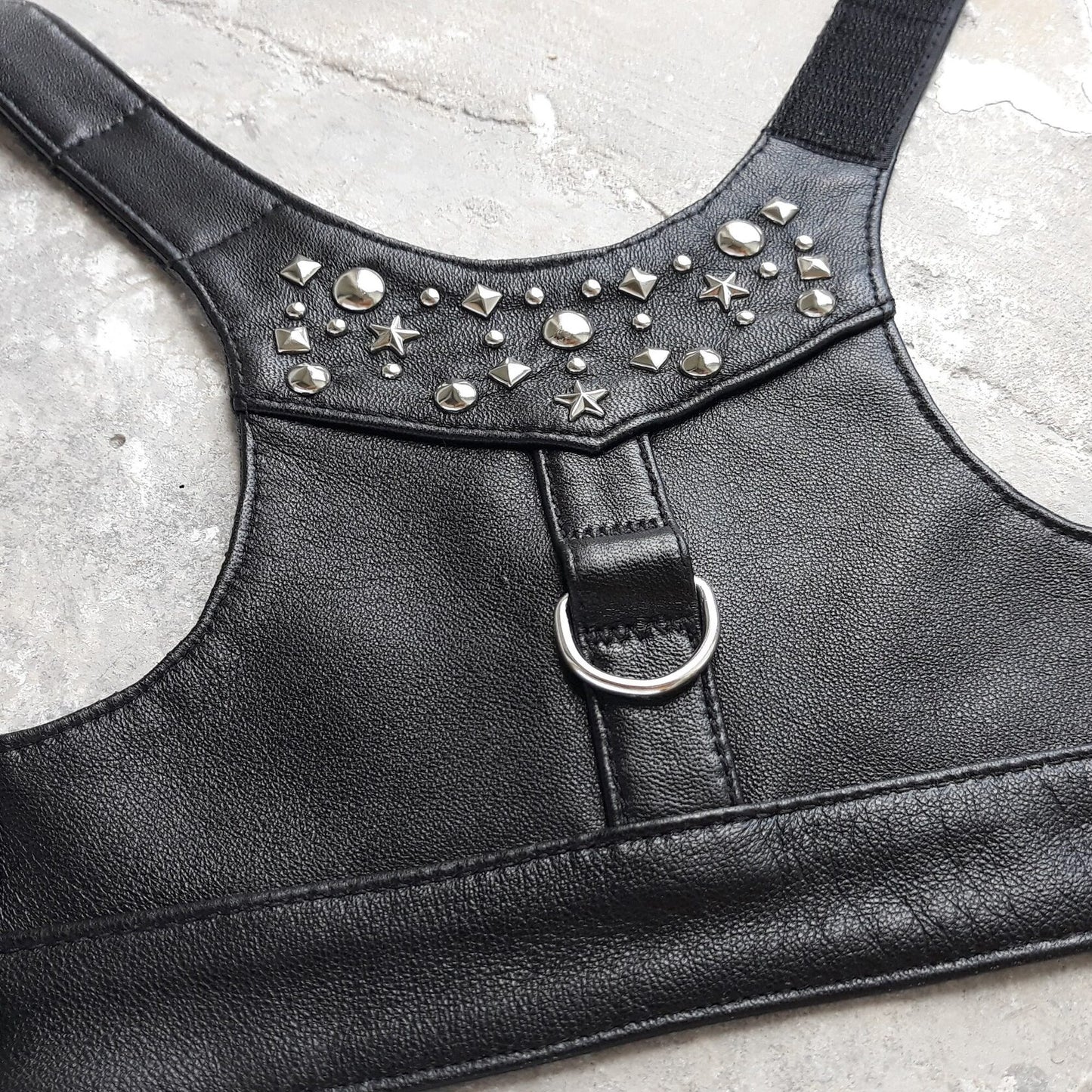Stylish black leather harness vest for cats with metallic rivets for a secure and fashionable fit