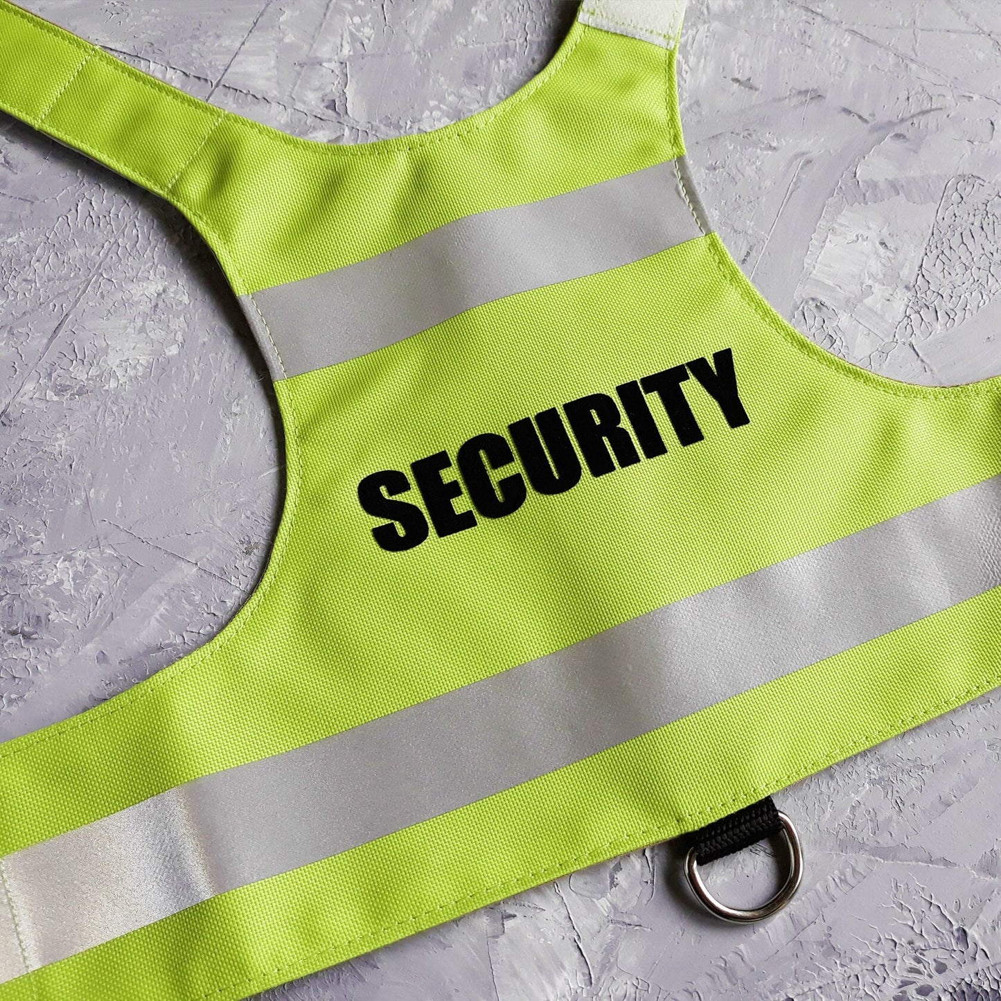 A bright green cat safety harness with the word "SECURITY" printed in black and two horizontal silver reflective stripes.