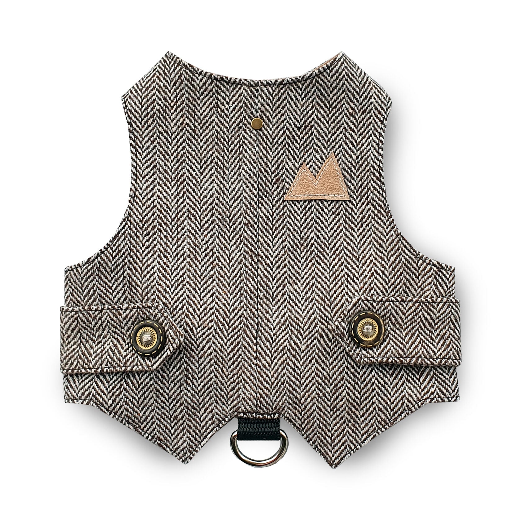 A brown and cream herringbone tweed cat harness with decorative bronze buttons, a brown faux leather mountain-shaped patch, and a black D-ring.