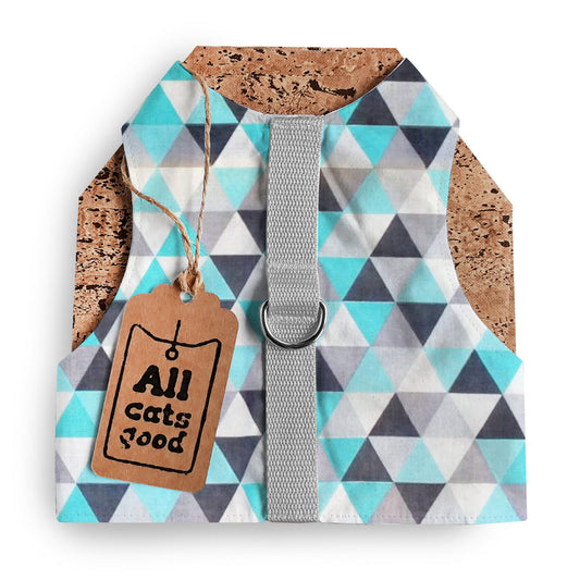A cat harness with a geometric triangle pattern in blue, grey, white, and black, a silver D-ring, a grey vertical strap, cork side panels, and an Allcatsgood tag.