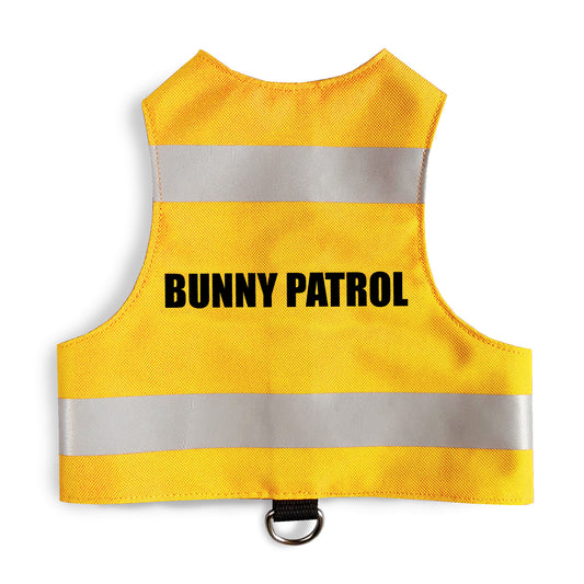 A bright yellow safety vest with horizontal reflective silver stripes and the text "BUNNY PATROL" in black capital letters. A black loop with a silver D-ring is at the bottom.