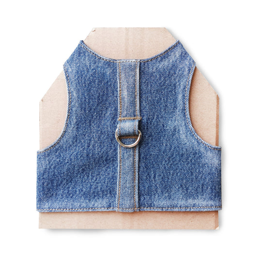 A cat harness made from blue denim fabric, featuring a central strap and a silver-colored D-ring.