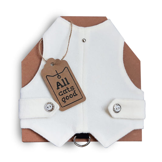 A white, classic-style cat harness from "Allcatsgood" is shown with a product tag bearing the brand's name. The harness has a clean design with snap closures for easy fastening and a D-ring for leash attachment.