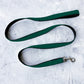 Green dog leash on a textured white surface