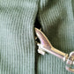 A green cotton sweater designed for a pet is shown on a white background