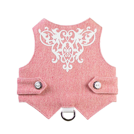 A pink tweed cat harness with white decorative embroidery on the back, silver and black buttons, and a silver D-ring.