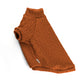 Orange cable-knit sweater for a cat with a high ribbed turtleneck, short sleeves, and a small white label near the hem.