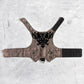 An overhead view of the inner lining of a brown tweed cat harness with a diagonal stripes pattern. The lining is a plain black fabric. A black leash attachment point with a silver D-ring is visible at the bottom.