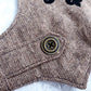 An overhead view of the inner lining of a brown tweed cat harness with a diagonal stripes pattern. The lining is a plain black fabric. A black leash attachment point with a silver D-ring is visible at the bottom.